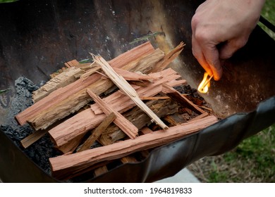 Starting the campfire in a firepit with kindling and safety matches. Camping lifestyle - Powered by Shutterstock