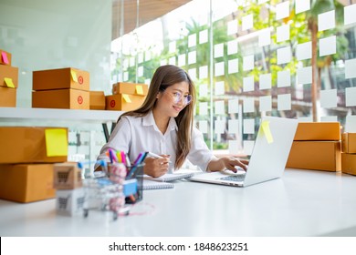 Starting Small business entrepreneur freelance,Portrait young woman working at home office, BOX,smartphone,laptop, online, marketing, packaging, delivery, SME, e-commerce concept  