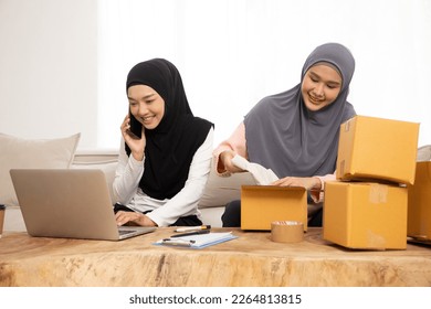 Starting small businesses SME Muslim owners women entrepreneurs Video calling with customers to receive and review orders online to prepare to pack boxes, sell to customers. Successful projects. - Powered by Shutterstock