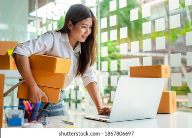 Starting small businesses SME owners female entrepreneurs Use a laptop or notebook to receive and review orders online to prepare to pack boxes, sell to customers, online sme business ideas.