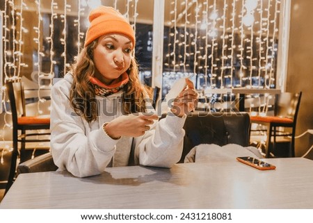 Startled woman scrutinizes the bill at the cafe, registering the crisis of emotion as she's shocked by the exorbitant price, realizing the hefty sum she must pay.