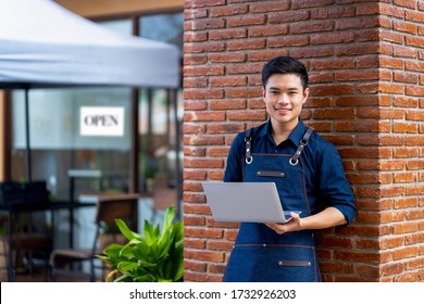 Startup Asian Young Small Business Owner Man Standing Front His Coffee Shop Or Restaurant. Portrait Of Successful Young Small Business Man Barista Cafe Owner.