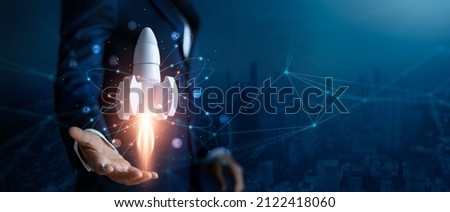 Startup business concept, Businessman control white rocket is launching and soar flying out from hand to sky for growth business,  Fast business success. Network connection on city background. 