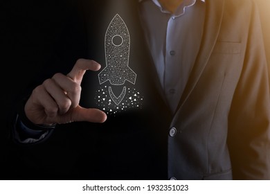 Startup business concept, Businessman holding icon transparent rocket is launching and soar flying out from screen with network connection on dark background