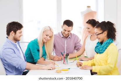 startup, education, fashion and office concept - smiling fashion designers working in office - Powered by Shutterstock