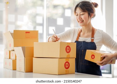 Startup Happy Asian Woman Business Owner Works With A Box At Home, Prepare Parcel Delivery SME Supply Chain, Procurement, Package Box To Deliver To Customers, Online SME Business Entrepreneurs Ideas,