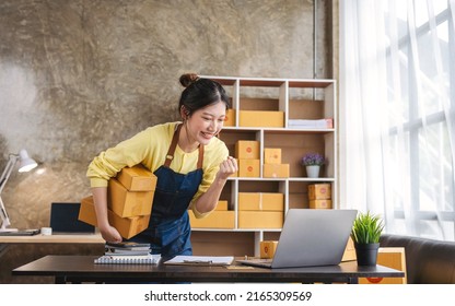 Startup Happy Asian Woman Business Owner Works With A Box At Home, Prepare Parcel Delivery SME Supply Chain, Procurement, Package Box To Deliver To Customers.