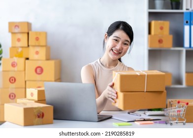 Startup Happy Asian Woman Business Owner Works With A Box At Home, Prepare Parcel Delivery SME Supply Chain, Procurement, Package Box To Deliver To Customers, Online SME Business Entrepreneurs Ideas