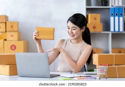 Startup Happy Asian Woman Business Owner Works With A Box At Home, Prepare Parcel Delivery SME Supply Chain, Procurement, Package Box To Deliver To Customers, Online SME Business Entrepreneurs Ideas