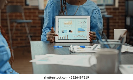 Startup manager showing analytics plan on digital tablet, presenting business statistics before working on profit development. Team of people examining annual data reports for research in office. - Powered by Shutterstock - Get 15% off with code: PIKWIZARD15