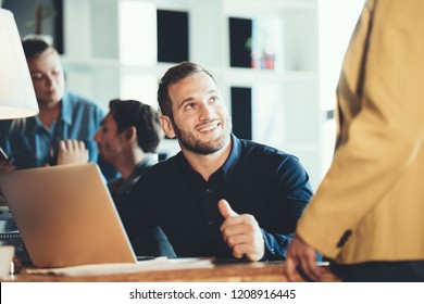 Startup And Millenial Business Concept. Man Talking To Team Mate Woman In Office