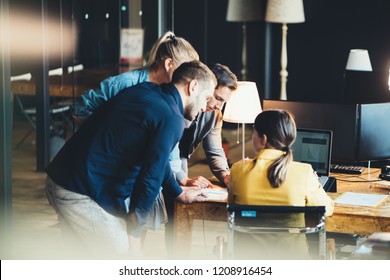 Startup And Millenial Business Concept. Team Of Four People Works Together In Big Office. Woman Explains New Strategy Changing