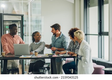 Startup multiracial business team on a meeting in a modern bright office interior. Woman team leader present project to her diverse colleagues.