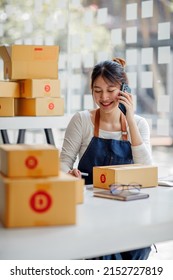 Startup Small Business Entrepreneur Or Freelance Asian Woman Using A Laptop With Box, Young Success Asian Woman With Her Hand Lift Up, Online Marketing Packaging Box And Delivery, SME Concept.