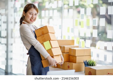 Startup small business entrepreneur SME or freelance Asian woman using a laptop with box, Young success Asian woman with her hand lift up, online marketing packaging box and delivery, SME concept. - Shutterstock ID 2146156303