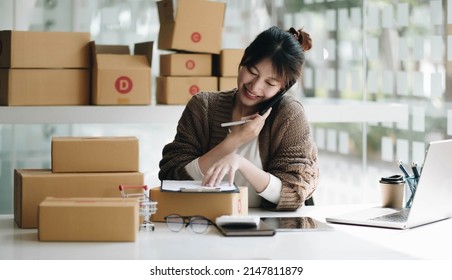 Startup Small Business Entrepreneur SME Freelance Woman Work With Smart Phone, Young Asian Small Business Owner Use Computer, Online Market Packing Box Delivery, SME E-commerce Telemarketing Concept
