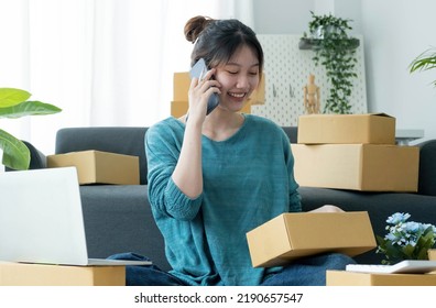 Startup Small Business Entrepreneur SME, Asian Woman Receive Order On Phone. Portrait Young Asian Small Business Owner Home Office, Online Sell Marketing Delivery SME E-commerce Telemarketing Concept
