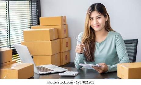 Startup Small Business Independent SME Entrepreneur Asian Young Woman Work At Home Box Smartphone Laptop Online Selling Marketing Packaging SME Shipping E-commerce Concept