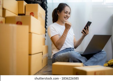 Startup small business SME, Entrepreneur owner using smartphone or tablet taking receive and checking online purchase shopping order to preparing pack product box.