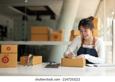 Startup SME Small Business Entrepreneur Of Freelance Asian Woman Using A Laptop With Box Cheerful Success Online Marketing Packaging Box And Delivery SME Idea Concept.