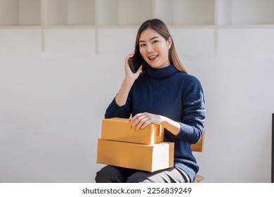 Startup SME small business entrepreneur of freelance Asian woman call phone with box white background, Cheerful success Asian woman online marketing packaging box and delivery SME idea concept - Powered by Shutterstock