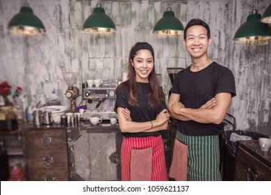 Startup successful small business owner man woman standing with arms crossed in cefe or restaurant. Portrait of young asian tan couple barista cafe owner. Small business entrepreneur together concept
