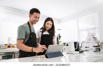 Startup successful small business owner sme boy girl stand with tablet in coffee shop restaurant. Portrait of asian tan man woman barista cafe owner. SME entrepreneur seller business delivery concept - Powered by Shutterstock