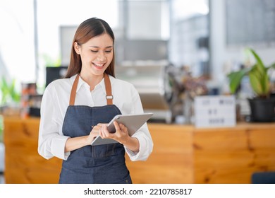 Startup successful small business owner sme beauty girl and apron hodding tablet at the bar of the modern cafe. Portrait of asian tan woman barista cafe owner. SME entrepreneur seller business concept - Powered by Shutterstock