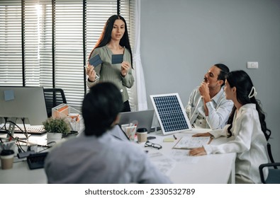 Startup team presents innovative, sustainable solar cell prototype. Reduce electricity costs, resource consumption, carbon footprint. Foster creative communication, eco-friendly decision-making. - Shutterstock ID 2330532789