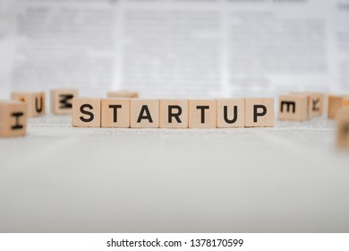 Startup Word Written In Wooden Cube - Newspaper 