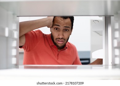 Starving Hungry Shocked Disappointed Young African American Man Checks Empty Fridge Got Stress In Kitchen, Inside Refrigerator. No Food, Diet, Facial Expression, Crisis And Emotions Bachelorand