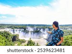 State of Paraná, Brazil - March 22, 2024: Tourist enjoying the views of Iguazu Falls, one of the Seven Natural Wonders of the World, located in the Iguazu National Park, on the border with Argentina.
