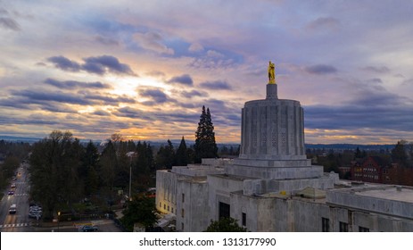 The state capital building adorned with the Oregon Pioneer with downtown Salem in the background