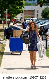 State College, Pennsylvania, August 10, 2016 - A Woman Carries Fans Ahead Of Students Moving Their Personal Belongings Into Their Dormitories On Move-in Day At Penn State University.