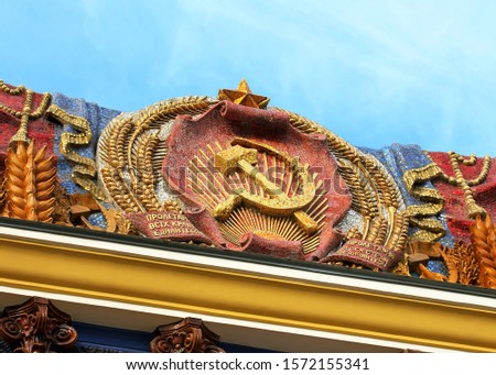 State emblem of the former Ukrainian Soviet Socialist Republic with gold sickle and hammer and  inscriptions: “Ukrainian RSR”,“Workers of all countries, unite!”, “Proletarian All-Ukrainian, come on!” 