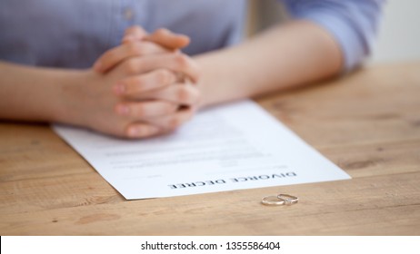 State employee, lawyer legalize divorce for ex family couple. Two marriage rings near divorce decree paper. Betrayal, no family, people relationship end, break up, conflict concept, close up view - Shutterstock ID 1355586404