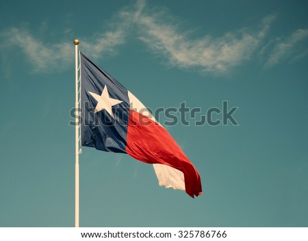 State flag of Texas against blue sky. Vintage filter effects.