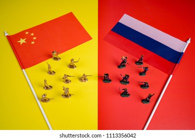 State flags of Russia and China. Close-up of miniature plastic toy soldiers at war. Concept of courage, fighting and patriotic spirit. Selective focus. Уellow and red background - Powered by Shutterstock