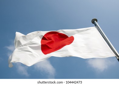 state Japanese flag on the strong wind over blue sky background