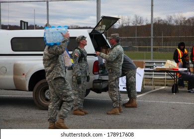 STATEN ISLAND, NEW YORK CITY - NOVEMBER 4 2012: Volunteers & National Guard Assembled At New Dorp High School To Render Aid To People Recovering From Hurricane Sandy. Guardsmen Confer & Carry Water