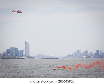 STATEN ISLAND, NY - MAY 24 2015: Orange Smoke From A Flare Held By A Rescue Swimmer Signals A US Coast Guard MH-65 Dolphin Helicopter During A Search And Rescue Demonstration For Fleet Week 2015.