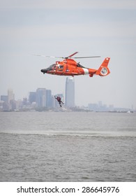 STATEN ISLAND, NY - MAY 24 2015: A Coast Guard Rescue Swimmer Waves When Hoisted By Line Into A US Coast Guard MH-65 Dolphin Helicopter For A Search And Rescue Demonstration For Fleet Week 2015.