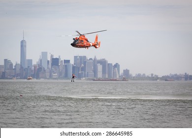 STATEN ISLAND, NY - MAY 24 2015: A Coast Guard Rescue Swimmer Is Hoisted By Line From The Water Into A US Coast Guard MH-65 Dolphin Helicopter For A Search And Rescue Demonstration During Fleet Week.