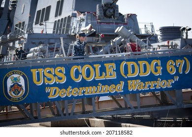 STATEN ISLAND, NY - MAY 25, 2014: A U.S. Navy Sailor Stops To Salute The American Flag Before Boarding The Guided-missile Destroyer USS Cole (DDG 067) Moored At Sullivans Piers For Fleet Week NY.