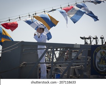 STATEN ISLAND, NY - MAY 25, 2014: A U.S. Navy Sailor Stops To Salute And Present His I.D. Card On The Guided-missile Destroyer USS McFaul (DDG 074) Moored At Sullivans Piers For Fleet Week NY.