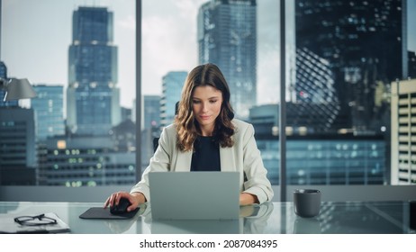 Static Portrait of Successful Caucasian Businesswoman Sitting at Her Desk Working on Laptop Computer in Big City Office. Confident Social Media Strategy Manager Plan Disruptive e-Commerce Campaign