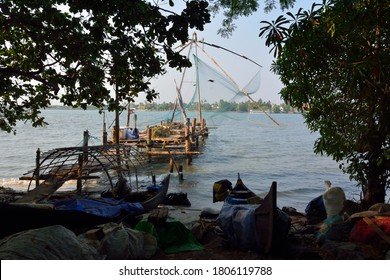 Stationary Chinese fishing nets (“Cheena vala” in Telugu) or shore operated lift nets seen through the trees at the sunset in Kochi Fort, Cochin, India
