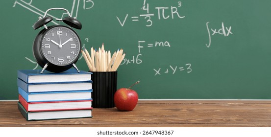 Stationery, alarm clock and apple on wooden table against school blackboard - Powered by Shutterstock - Get 15% off with code: PIKWIZARD15