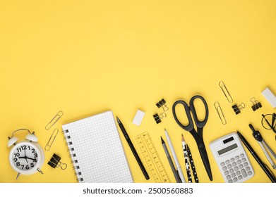 Stationery in black and white, notebooks, alarm clock and calculator on a yellow background. Back to school concept. Workspace organization. Copy space. - Powered by Shutterstock