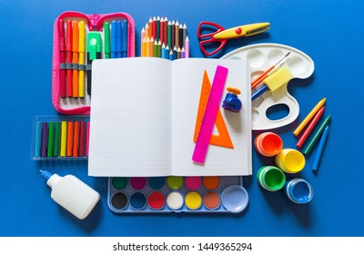 Stationery flat lay  Bright material for child Back to school  Blue background kid child  Around office supplies are the color the rainbow 